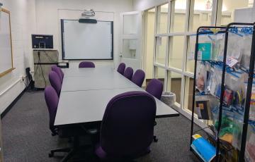 Curriculum lab with table, smart screen, podium, and educational materials